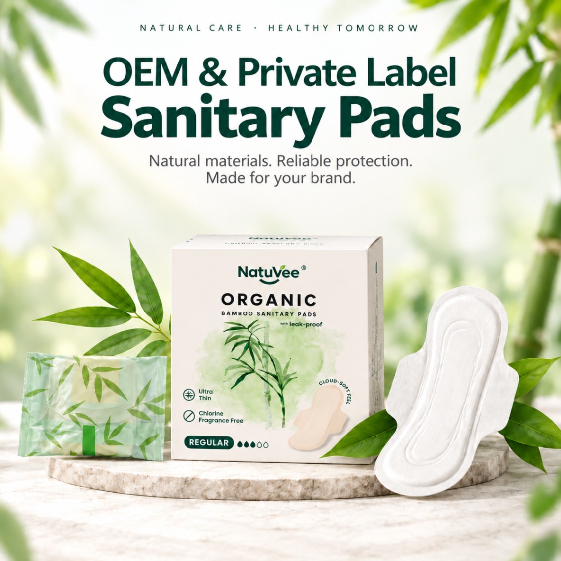 NatuVee organic bamboo sanitary pads box, individual wrapper, and open pad on a stone pedestal with bamboo leaves.